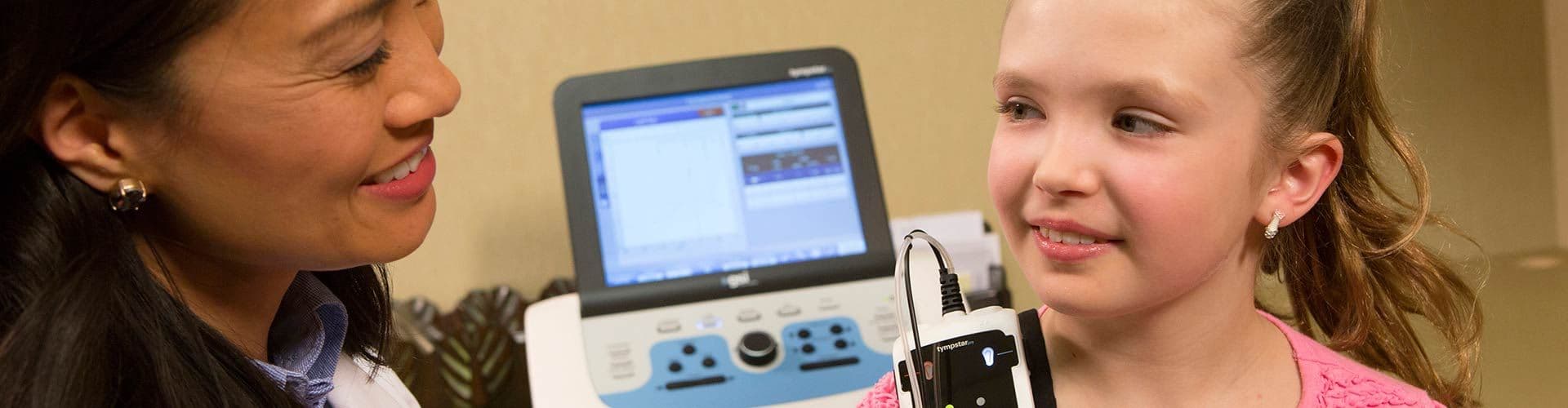 Audiologist performing middle ear testing on a child